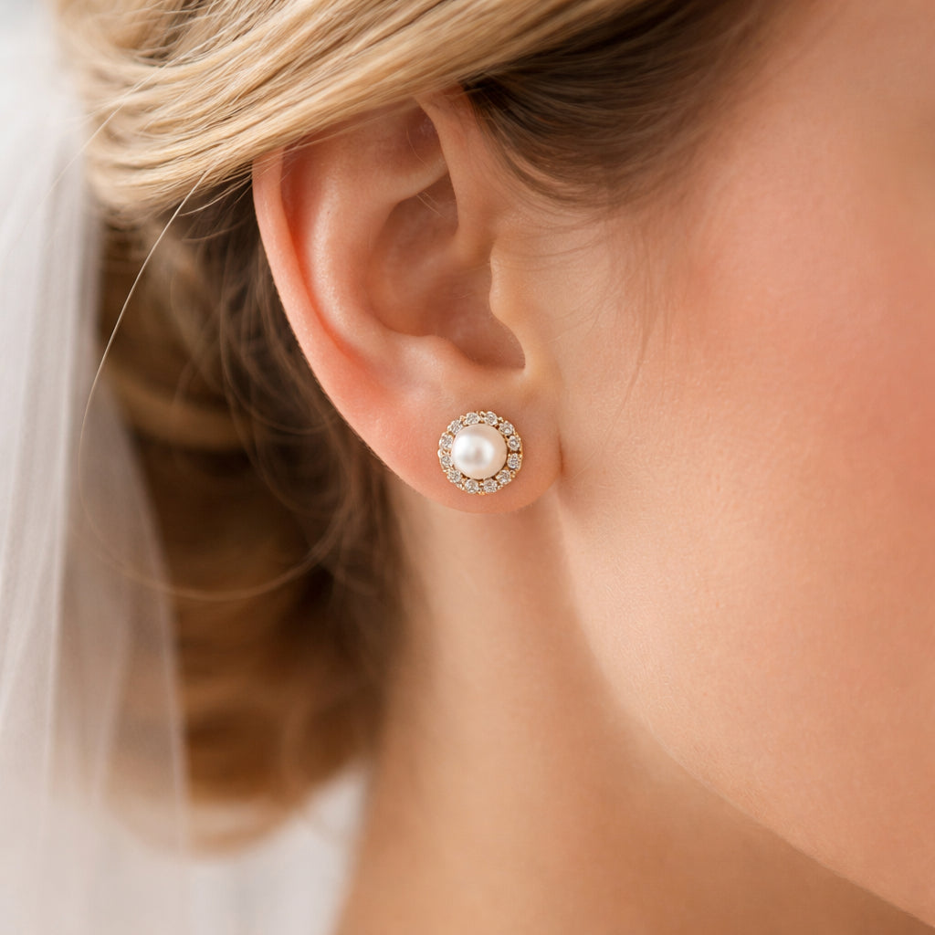 A close‑up of a bride’s ear wearing elegant freshwater pearl and 18k gold vermeil studs, Realism style. Alt: best gemstone earrings for weddings with pearl studs