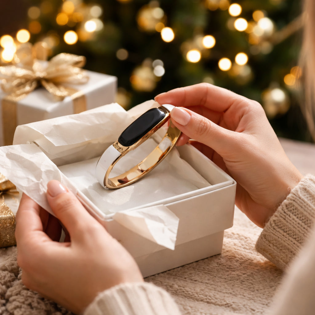A photorealistic scene of a woman unwrapping a sleek, gold‑accented smart bracelet, with soft holiday lights in the background, showcasing the blend of luxury jewellery and modern technology. Alt: Christmas gifts for women featuring tech‑savvy jewellery.