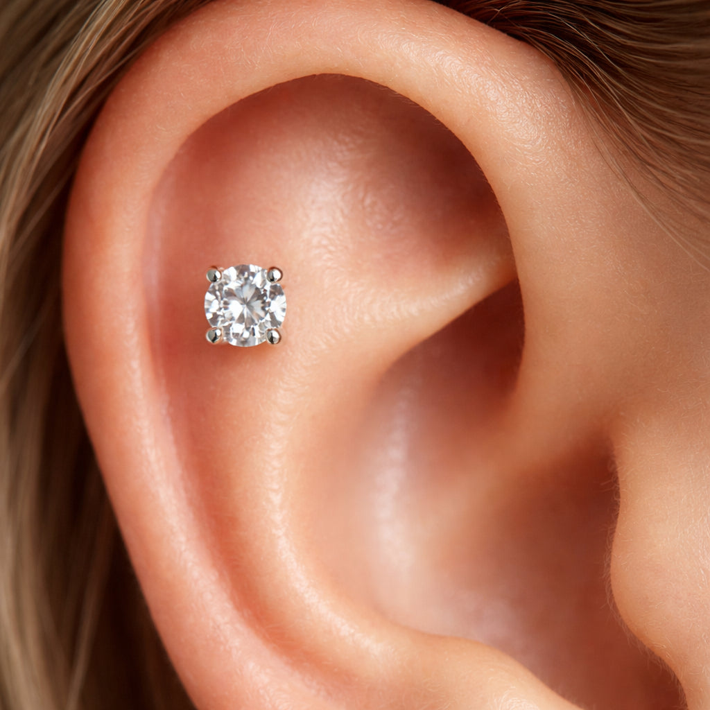 A close‑up photorealistic view of a single diamond cartilage stud set in white gold, the diamond sparkling against smooth ear cartilage. Alt: high‑quality diamond cartilage earrings with perfect cut and low profile setting.