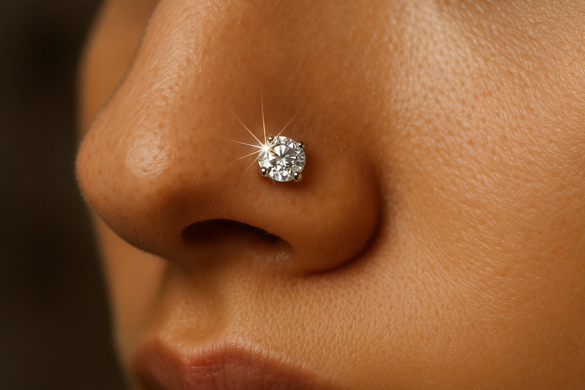 A close-up of a sparkling diamond nose stud on a model’s nostril. Alt: Diamond nose stud sparkling on nostril piercing.