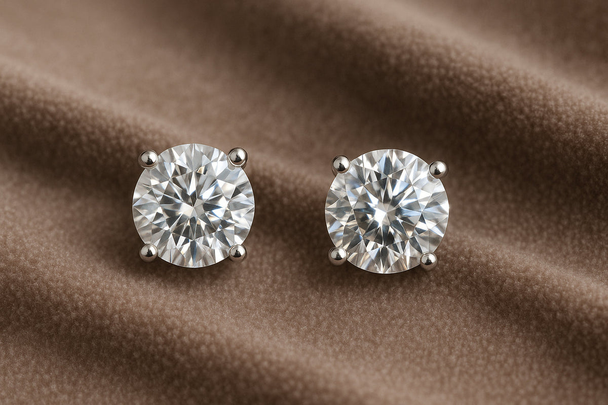 A pair of sparkling diamond stud earrings placed on a soft velvet background. Alt: Beautiful diamond studs showcasing brilliant sparkle.