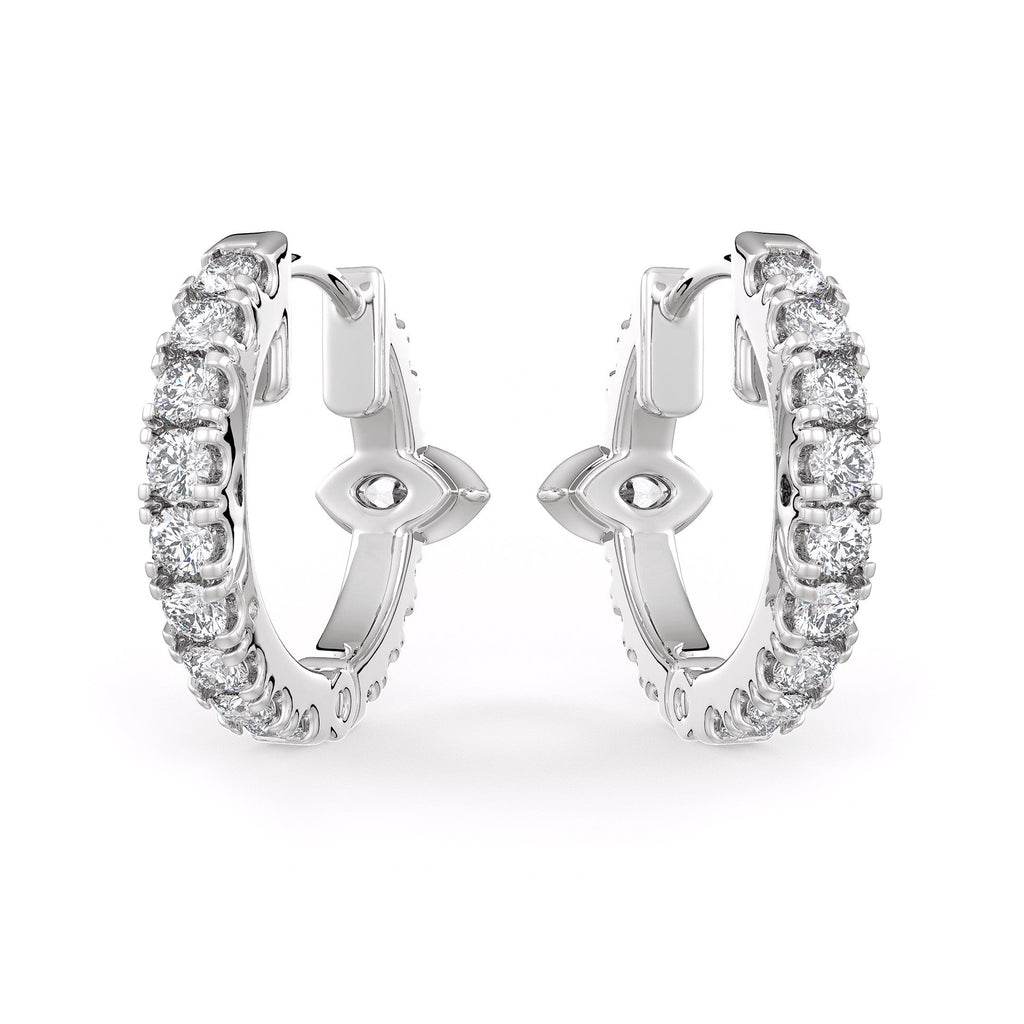 Pair of silver hoop earrings with clear gemstones on a white background