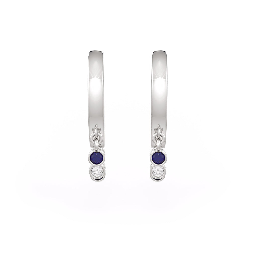 Pair of silver hoop earrings with blue gemstones on a white background