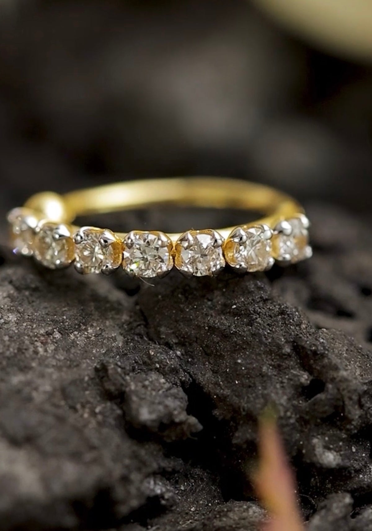 Gold stud with diamonds on a dark textured surface