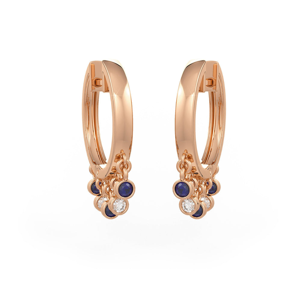 Rose gold hoop earrings with blue gemstones and clear stones on a white background