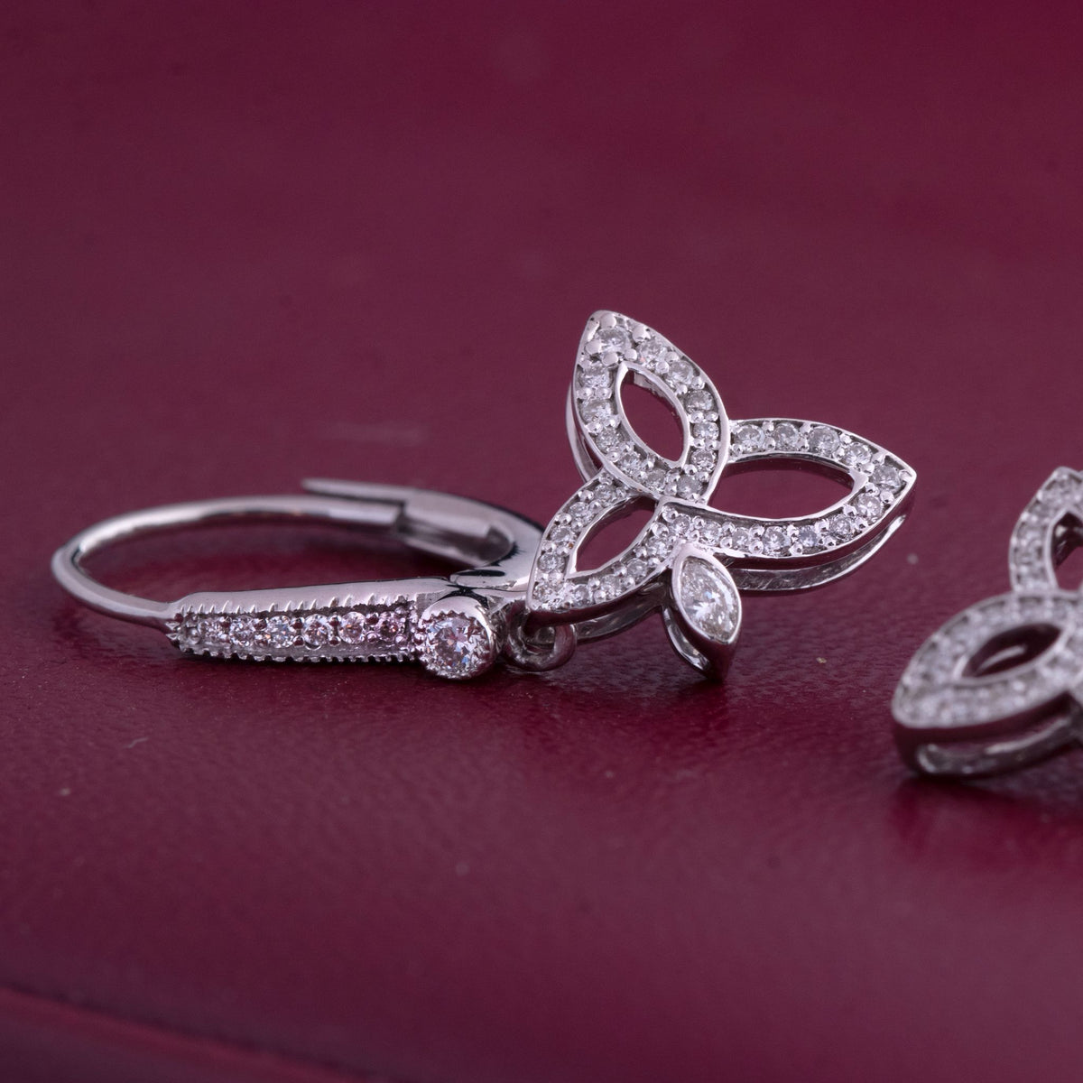 Butterfly earrings with clear gemstones on a red background