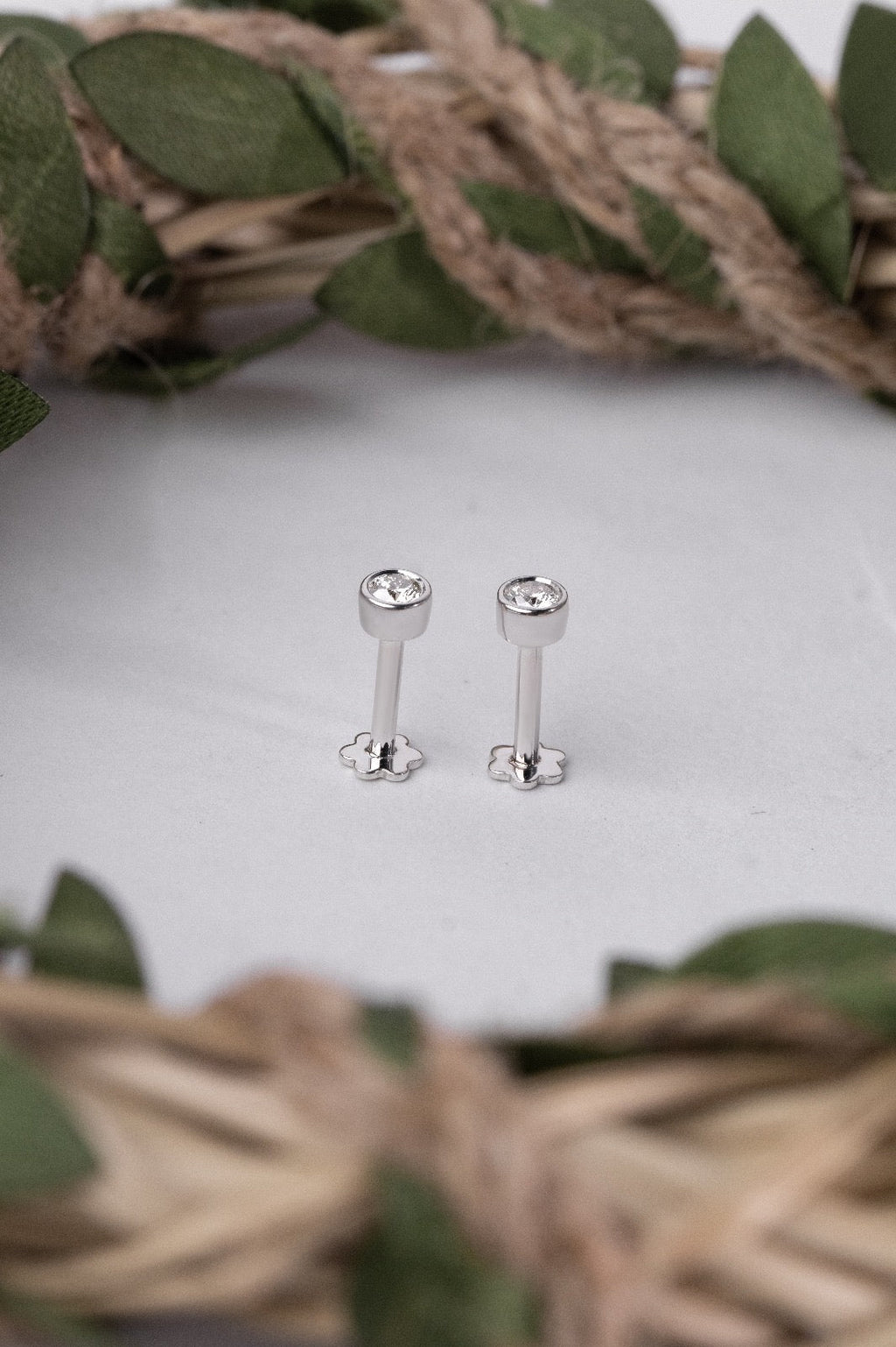 Elegant silver nose stud with a small gemstone on a white surface.