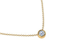 Gold necklace with a single diamond pendant on a white background