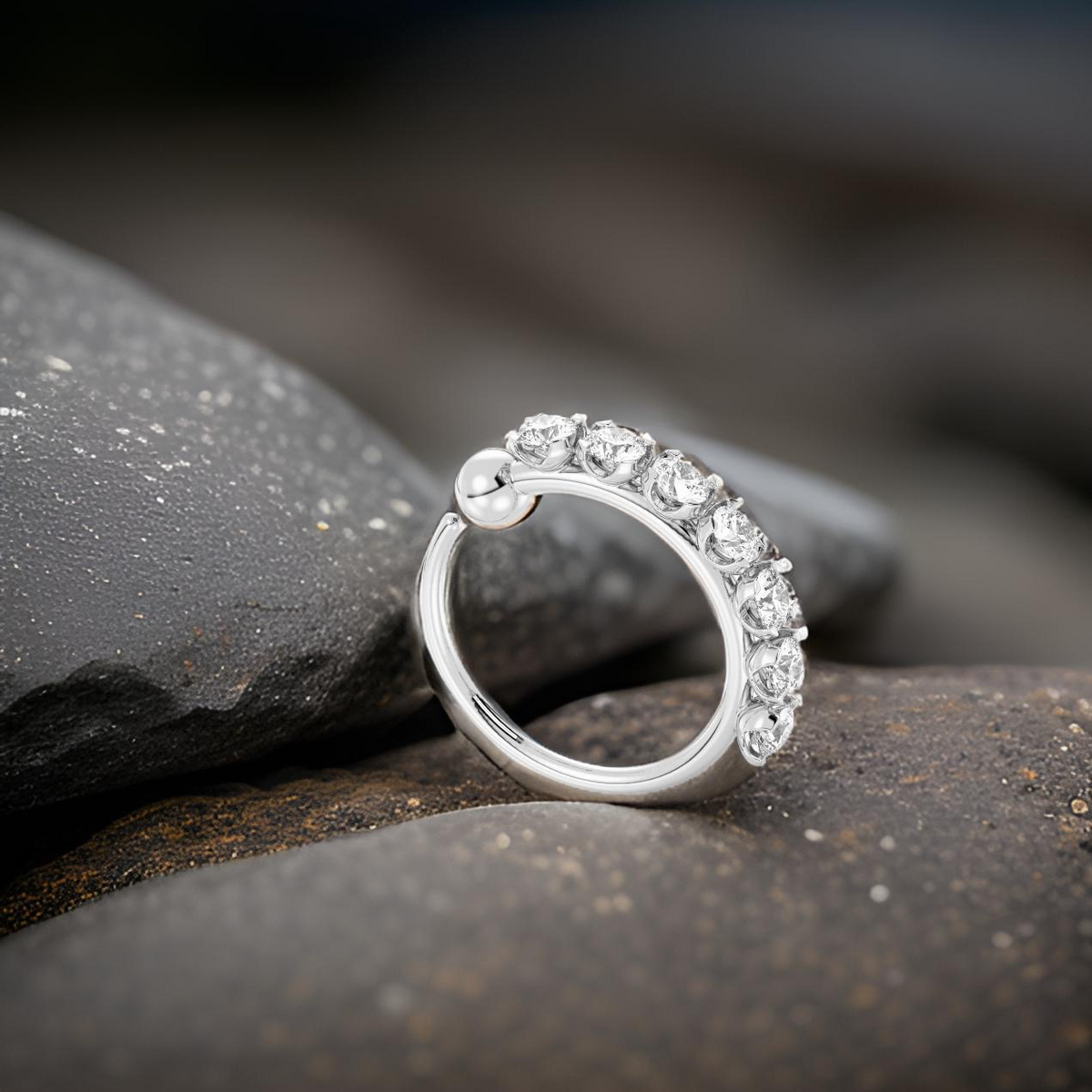 Silver ring with diamonds on a dark stone surface