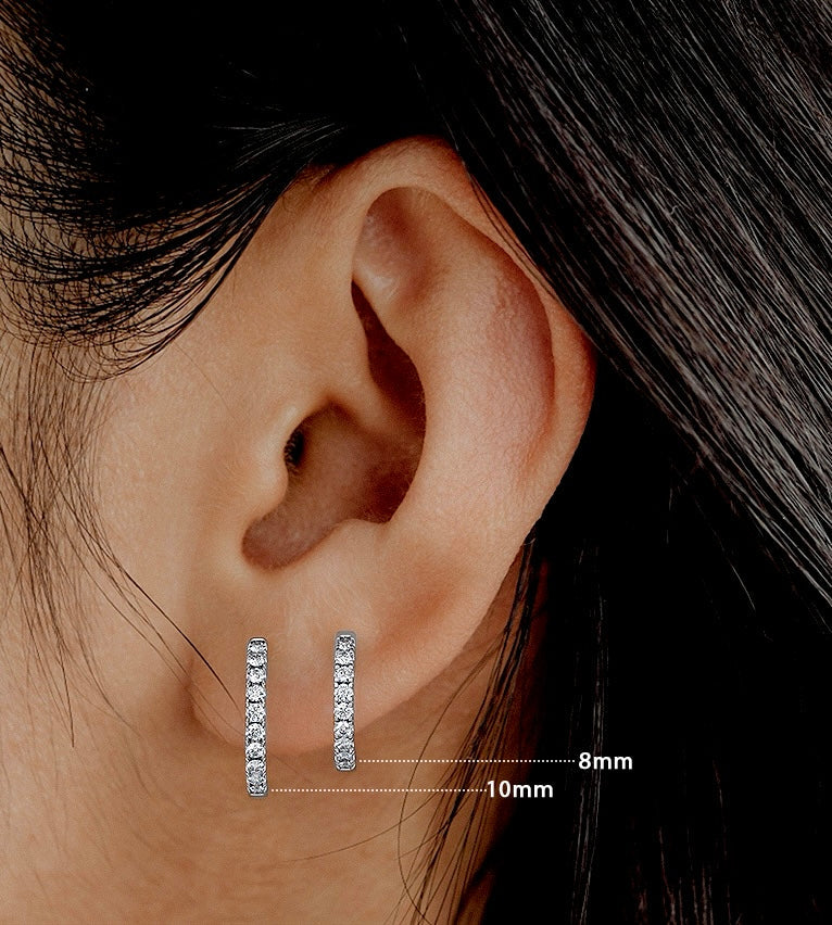 Close up of an ear wearing silver hoop earrings with size measurement details