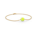 Gold bracelet with a green tennis ball charm on a white background