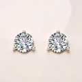 Pair of diamond stud earrings on a light pink background