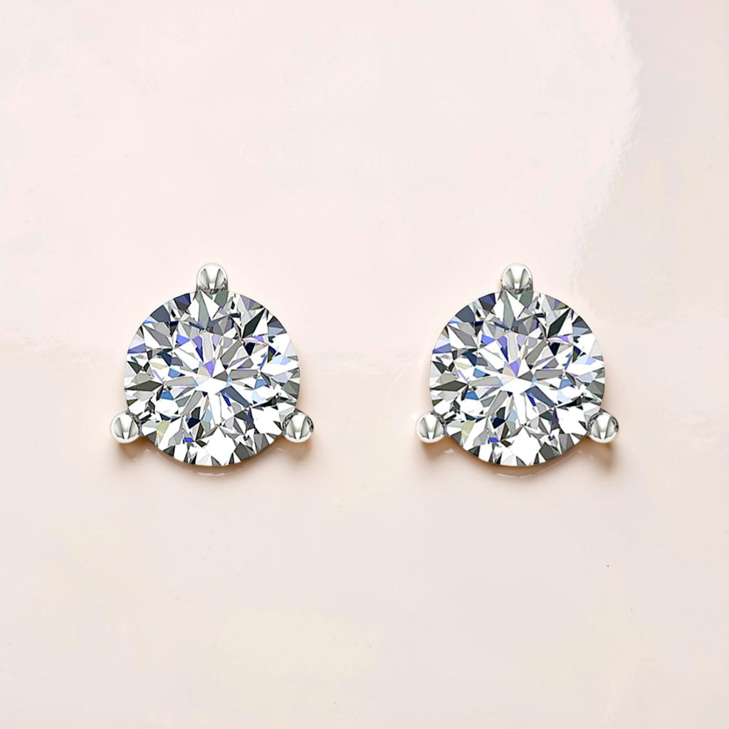 Pair of diamond stud earrings on a light pink background