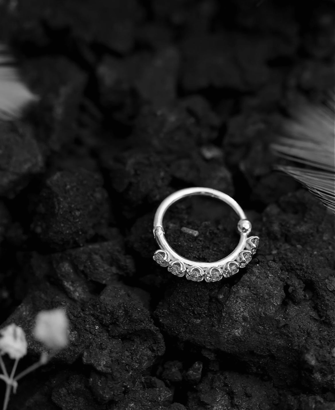 Silver ring with gemstones on a dark textured surface