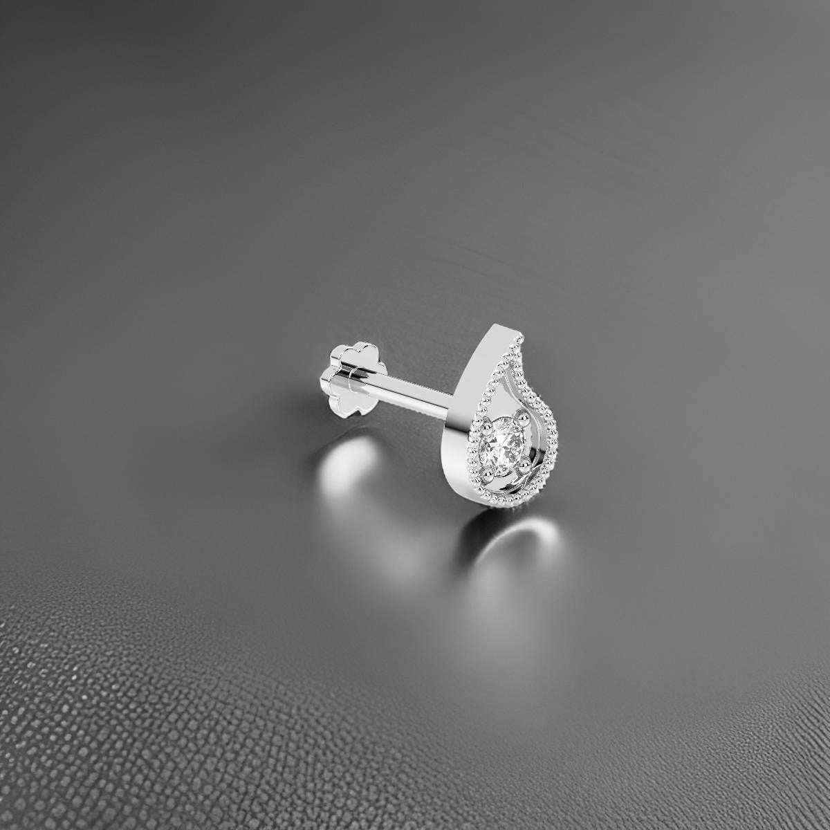 Silver nose stud with a clear gemstone on a gray background