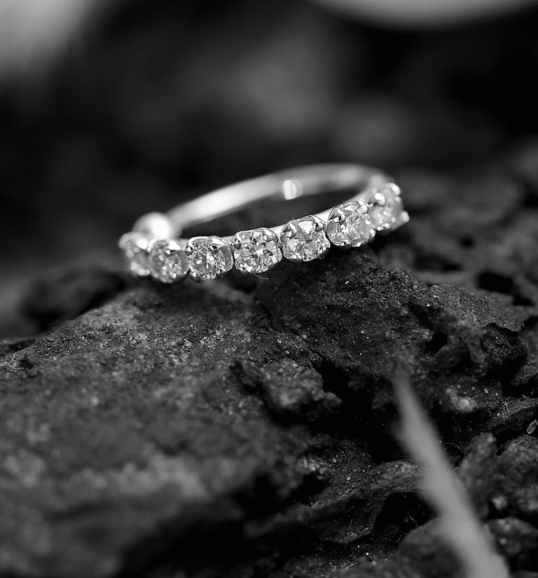 Silver ring with diamonds on a dark textured surface