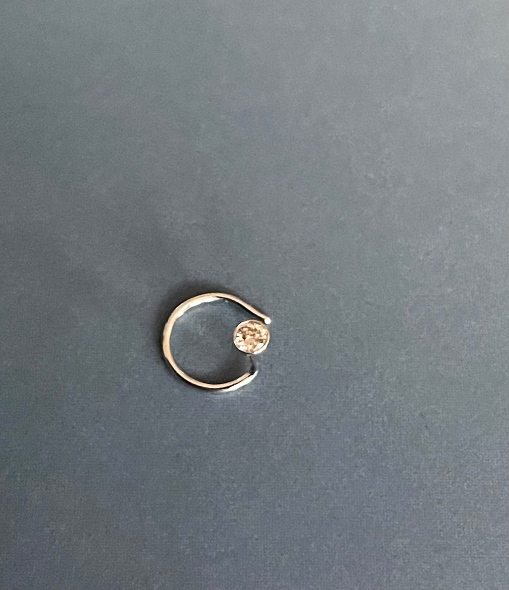 Gold ring with a small gemstone on a dark gray background