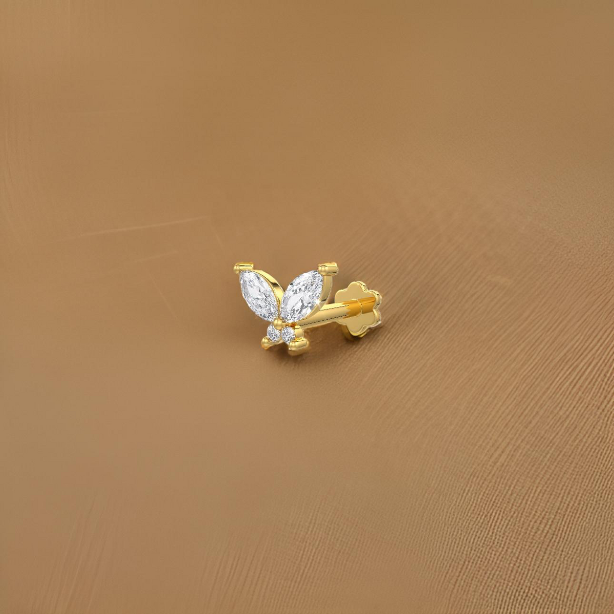 Gold butterfly-shaped nose stud on a brown background