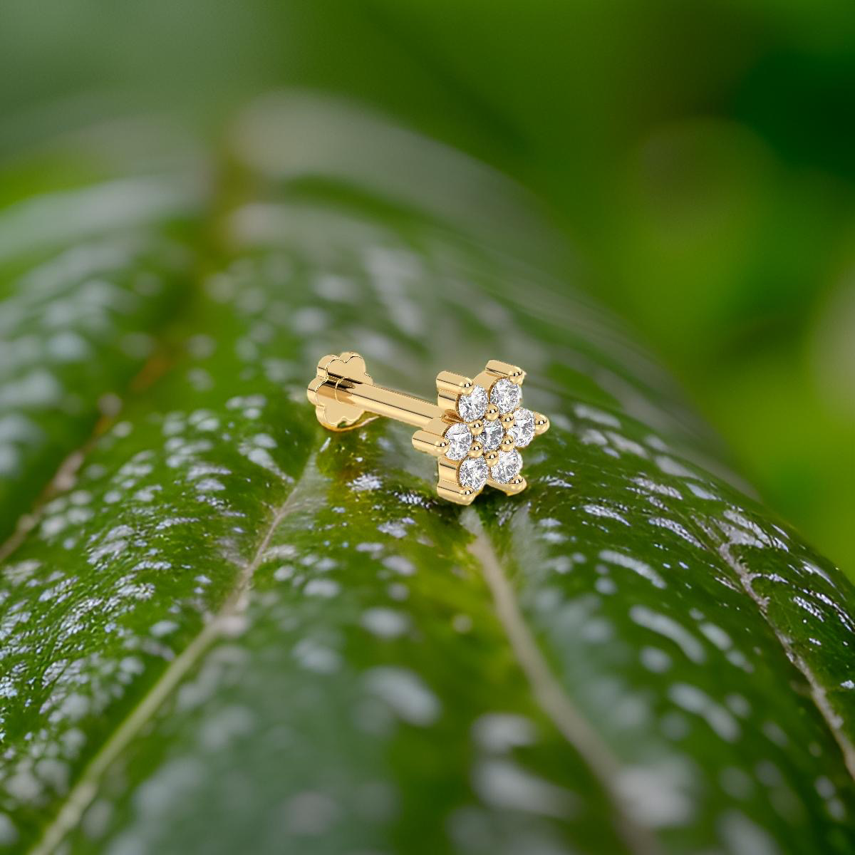 Yellow gold nose stud with diamonds on a green leaf