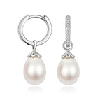 Sterling silver earrings with lab-grown diamond accents and oval freshwater pearl drops from Hatton Garden Collection.