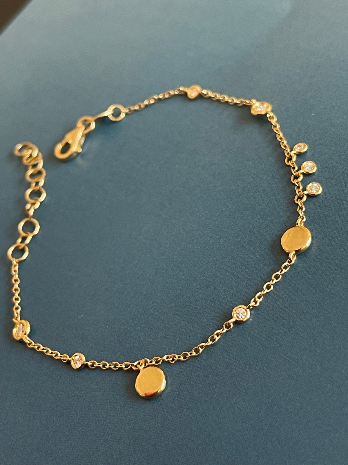 Bracelet en or jaune 18 carats serti de diamants (0,15 carat) avec breloques en forme de disque et pendentifs clos.