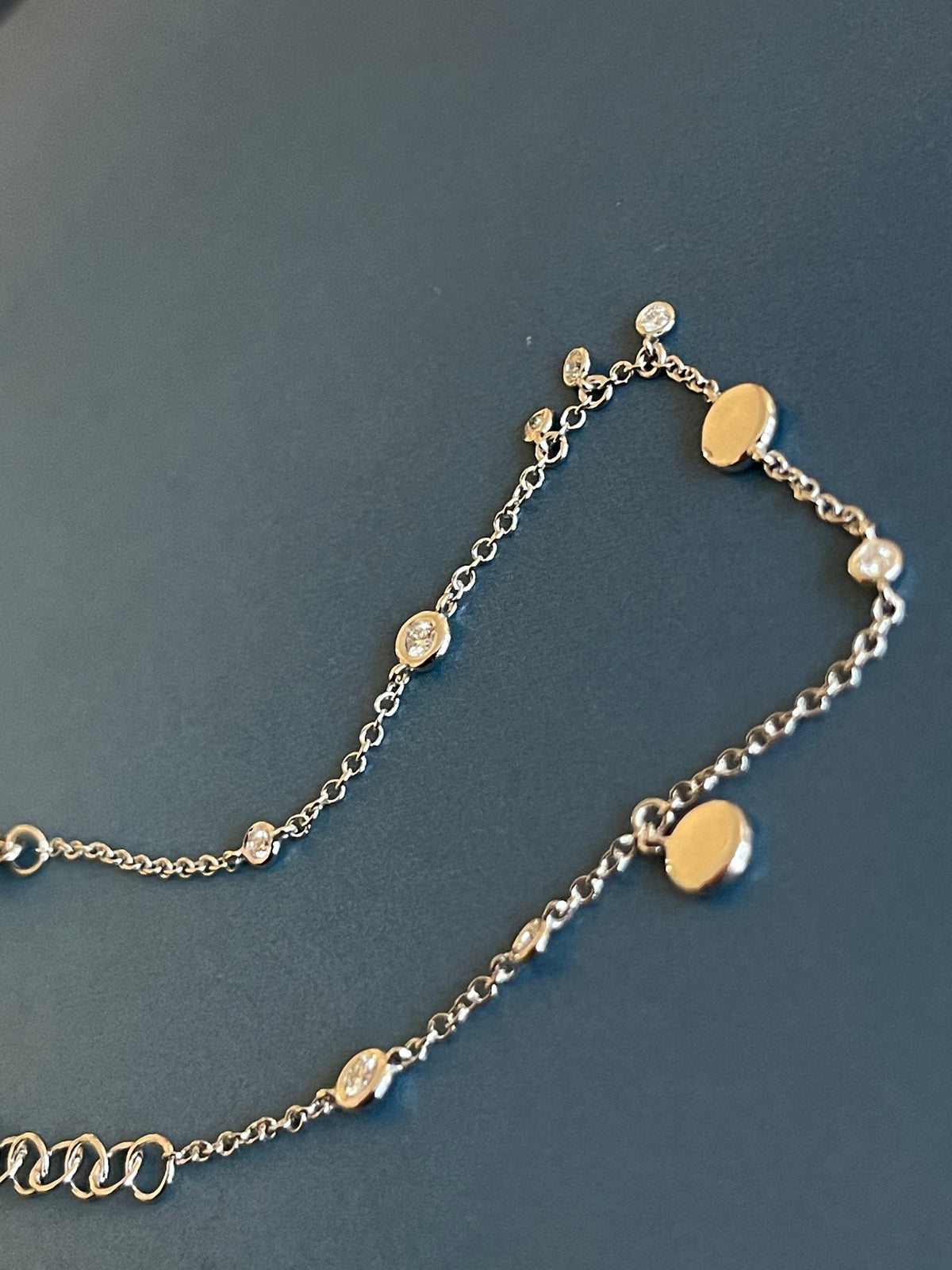 Bracelet en or blanc 18 carats serti de diamants (0,15 carat) avec breloques en forme de disque et pendentifs clos.