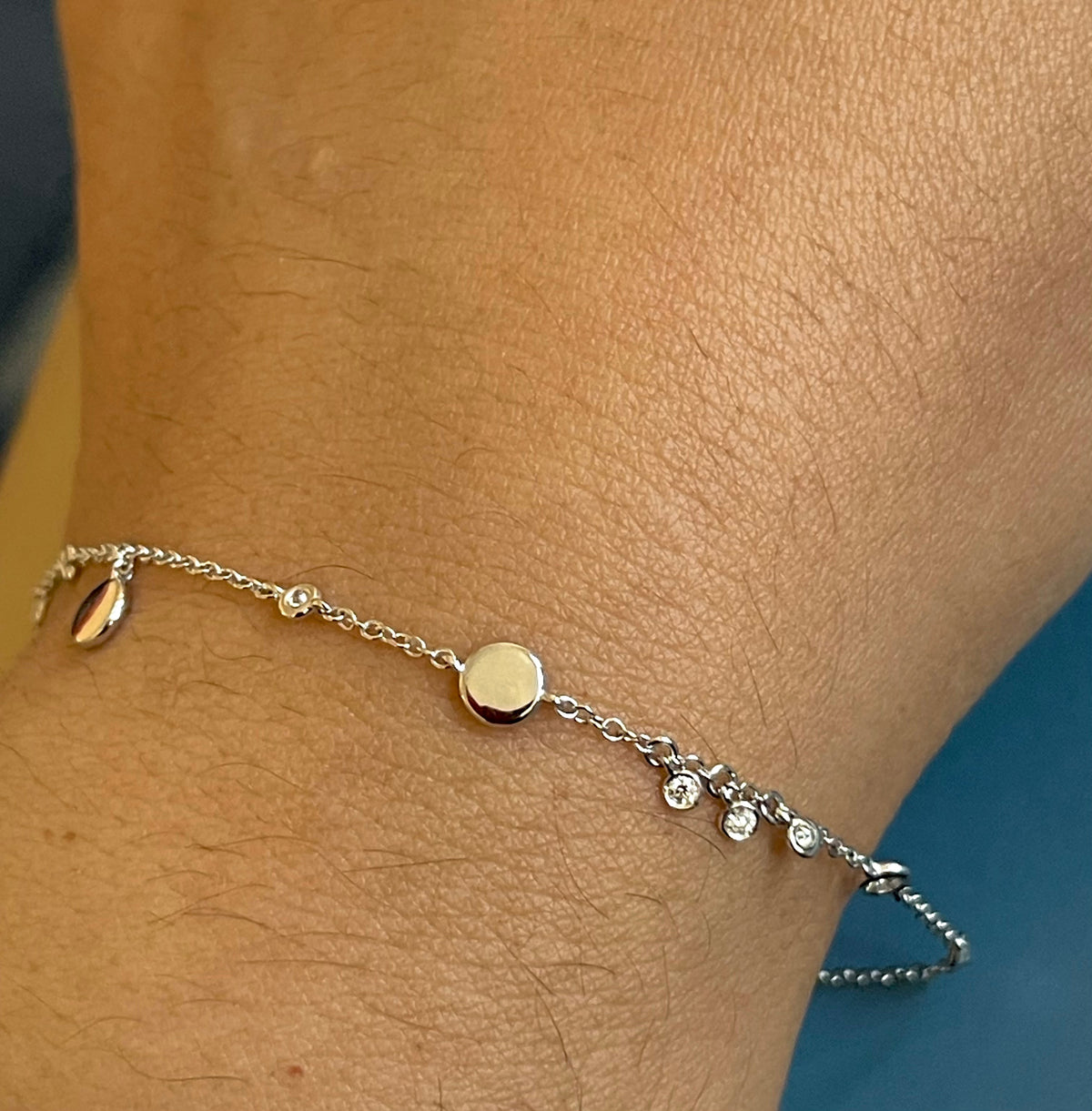 Bracelet en or blanc 18 carats serti de diamants (0,15 carat) avec breloques en forme de disque et pendentifs clos.