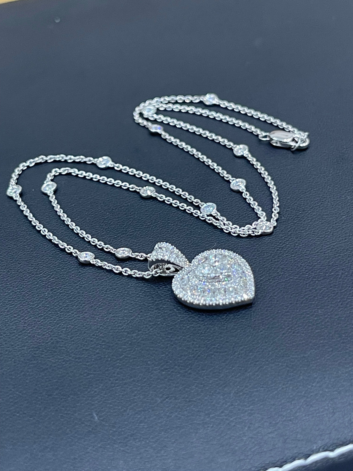Collier en or blanc serti de diamants en forme de cœur et orné d'une chaînette de diamants dispersés
