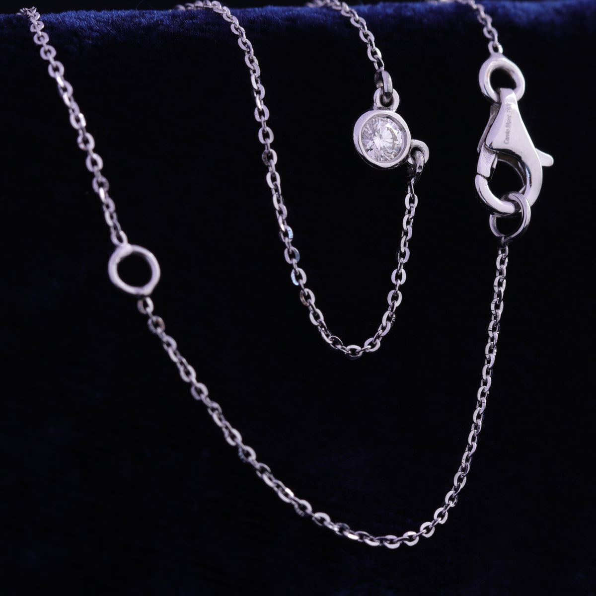 Close view of bezel set solitaire diamond necklace in rose gold